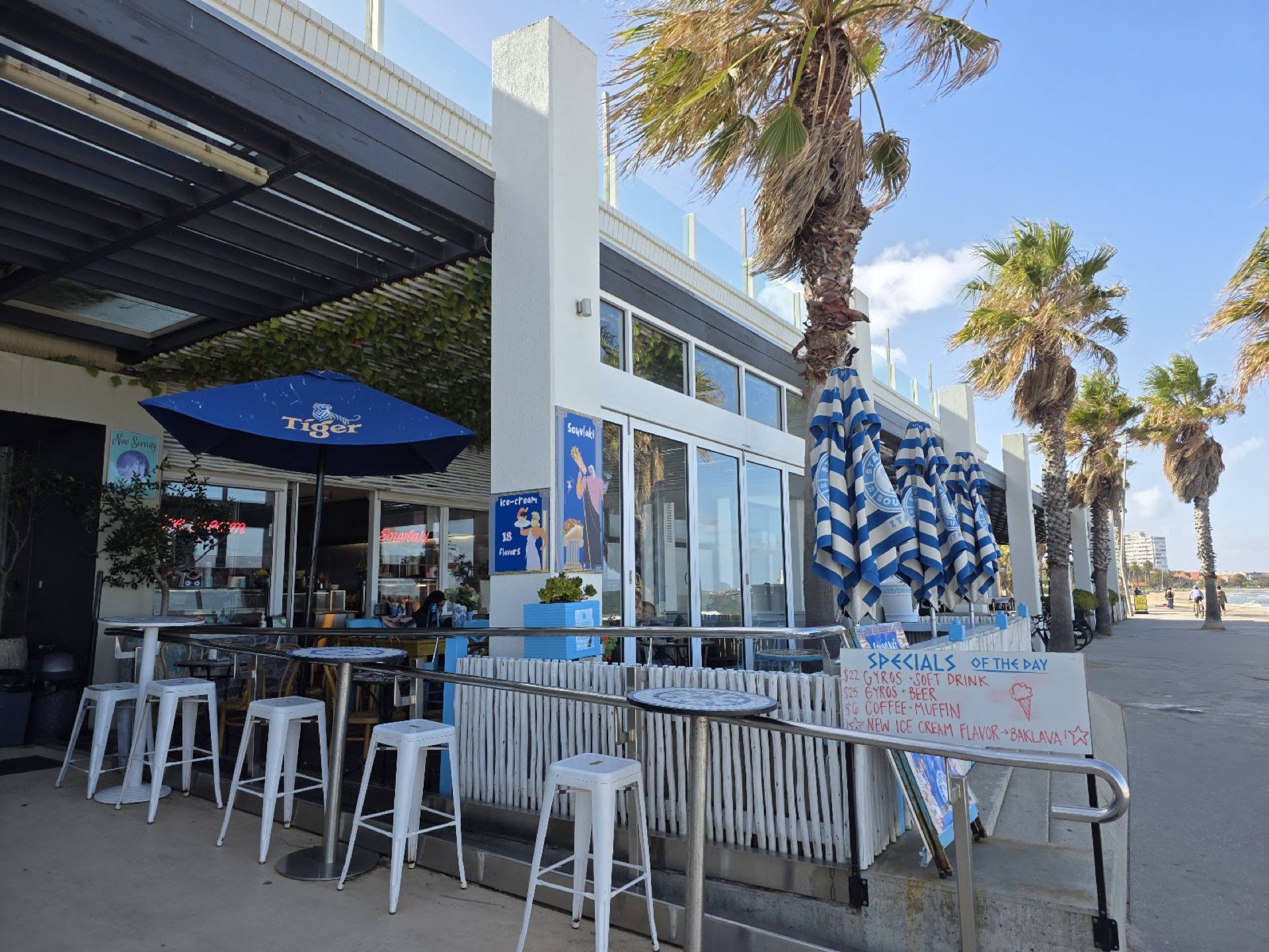 Stavros Souvlaki on the St Kilda Sea Baths boardwalk, with palms and the beach behind